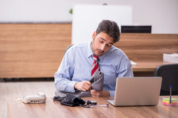 Young male employee suffering from hypertension at workplace