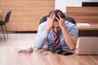 Young male employee suffering from hypertension at workplace