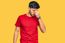 Young Handsome Man Wearing Casual Red Tshirt Tired Rubbing Nose And Eyes Feeling Fatigue And Headache. Stress And Frustration Concept.