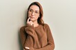 © Krakenimages.com - Young caucasian woman wearing casual clothes and glasses thinking concentrated about doubt with finger on chin and looking up wondering