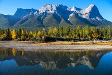River Reflection With Mountains And Colourful Autumn Trees On Sunny Blue Sky Day 