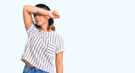 Poster - Young woman wearing casual clothes covering eyes with arm, looking serious and sad. sightless, hiding and rejection concept