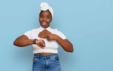 Sticker - Young african woman with turban wearing hair turban over isolated background in hurry pointing to watch time, impatience, upset and angry for deadline delay