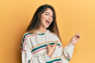 Poster - Young caucasian woman wearing casual clothes smiling and looking at the camera pointing with two hands and fingers to the side.