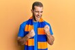 © Krakenimages.com - Young caucasian man football hooligan cheering game celebrating surprised and amazed for success with arms raised and eyes closed