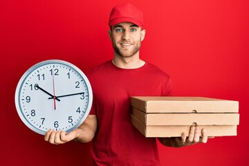 Sticker - Young caucasian man holding delivery package and clock smiling with a happy and cool smile on face. showing teeth.