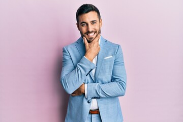 young hispanic businessman wearing business jacket looking confident at the camera smiling with cros