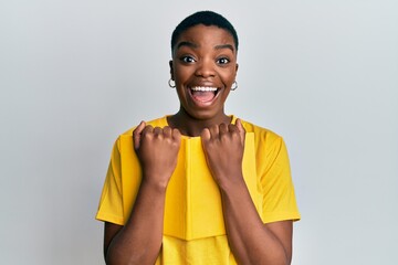 Sticker - Young african american woman holding book celebrating crazy and amazed for success with open eyes screaming excited.