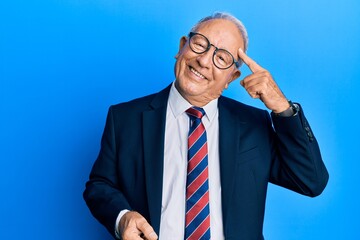 Poster - Senior caucasian man wearing business suit and tie smiling pointing to head with one finger, great idea or thought, good memory