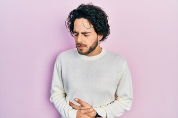 Sticker - Handsome hispanic man wearing casual white sweater with hand on stomach because indigestion, painful illness feeling unwell. ache concept.