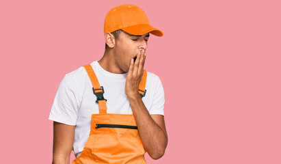 Canvas Print - Young handsome african american man wearing handyman uniform bored yawning tired covering mouth with hand. restless and sleepiness.