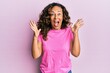© Krakenimages.com - Middle age hispanic woman wearing casual clothes celebrating crazy and amazed for success with arms raised and open eyes screaming excited. winner concept