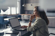 © undrey - Business woman in a suit working with a laptop at her desk in her home office