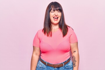 Poster - Young plus size woman wearing casual clothes winking looking at the camera with sexy expression, cheerful and happy face.