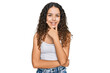 © Krakenimages.com - Teenager hispanic girl wearing casual clothes looking confident at the camera smiling with crossed arms and hand raised on chin. thinking positive.