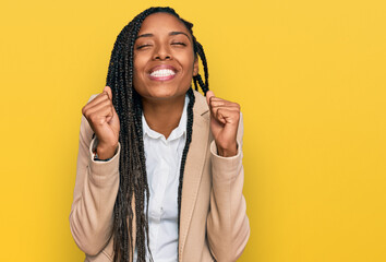 African american woman wearing business jacket excited for success with arms raised and eyes closed celebrating victory smiling. winner concept.