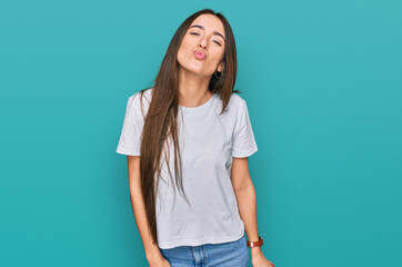 Sticker - Young hispanic girl wearing casual white t shirt looking at the camera blowing a kiss on air being lovely and sexy. love expression.