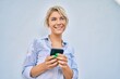 © Krakenimages.com - Young blonde woman smiling happy using smartphone at the city.