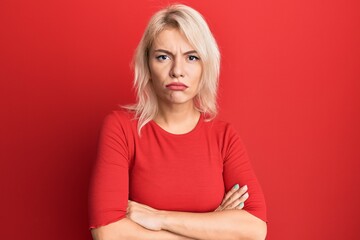 Poster - Young blonde girl wearing casual clothes skeptic and nervous, disapproving expression on face with crossed arms. negative person.