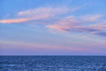 Wall Mural - sunset and pink clouds over the blue calm sea