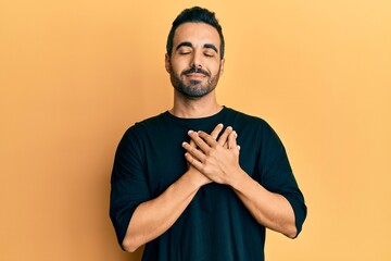 Poster - Young hispanic man wearing casual clothes smiling with hands on chest, eyes closed with grateful gesture on face. health concept.