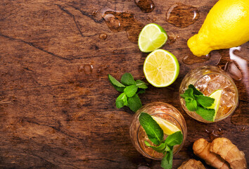 Ginger Ale Cocktail with Beer, Lime, Lemon and Mint in glaass on wooden table, top view