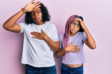 Wall Mural - Beautiful african american mother and daughter wearing casual clothes and glasses touching forehead for illness and fever, flu and cold, virus sick