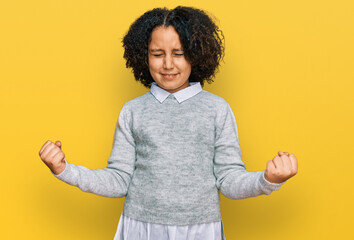 Sticker - Young little girl with afro hair wearing casual clothes very happy and excited doing winner gesture with arms raised, smiling and screaming for success. celebration concept.