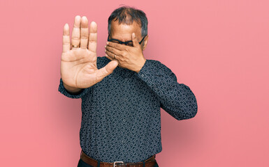 Poster - Middle age indian man wearing casual clothes and glasses covering eyes with hands and doing stop gesture with sad and fear expression. embarrassed and negative concept.