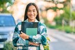 © Krakenimages.com - Young latin student girl smiling happy holding folder at the city.