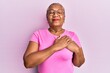 Senior african american woman wearing casual clothes and glasses smiling with hands on chest with closed eyes and grateful gesture on face. health concept.
