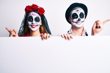 Sticker - Couple wearing day of the dead costume holding blank empty banner smiling happy pointing with hand and finger to the side