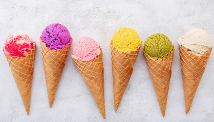 Leinwandbilder - Various of ice cream flavor in cones blueberry ,pistachio ,almond ,orange and cherry setup on white stone background . Summer and Sweet menu concept.