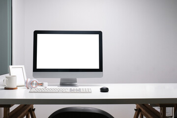 Modern workspace with computer with blank screen and equipment on white table.Blank screen for your information.