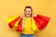 © Maria - Smiling woman hold package bags with purchases isolated on yellow background studio. Shopping discount sale concept. Mock up,copy space, banner. Black friday