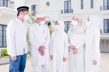 Wall Mural - Muslim family in mask chatting in front of house