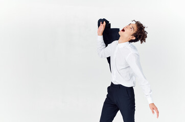 man with curly hair and in a classic suit holds a jacket in his hand fashion style