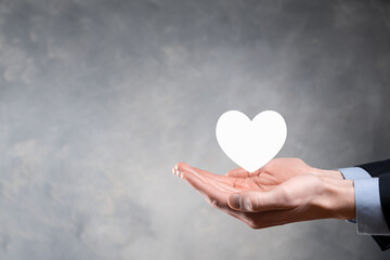 Wall Mural - Hand holding red heart with white cross symbol. World map background. Health care, Health insurance, Charity, and Medicine concept. Copy space.