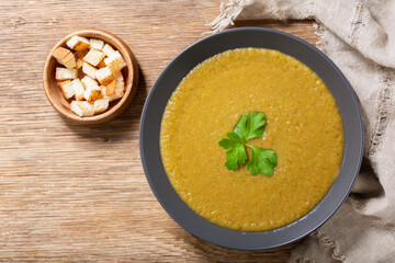 Sticker - plate of vegetable cream soup on a wooden background,