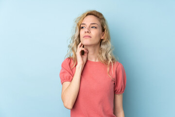 Poster - Young blonde woman isolated on blue background thinking an idea