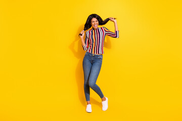 Poster - Full length photo of attractive positive dark skin girl closed eyes arms hold play with hair isolated on yellow color background