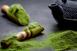 Powdered green tea and set for matcha on black background
