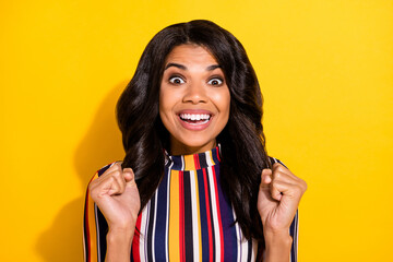 Wall Mural - Photo portrait of amazed shocked woman gesturing like winner smiling isolated on bright yellow color background