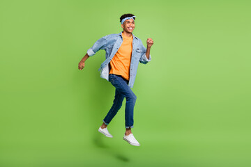 Poster - Profile photo of guy jump run look empty space wear headband denim shirt footwear isolated green color background