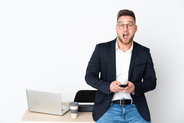 Russian man in a office isolated on white background surprised and sending a message