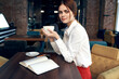 © SHOTPRIME STUDIO - beautiful woman with a cup in hand sits at a table in a cafe and book a restaurant