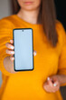 © perfectlab - Woman hold mobile phone screen mockup in hands in orange sweater