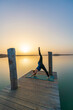 © DZiegler - Portrait of a pregnant woman doing yoga at a lake during a beautiful sunset