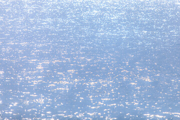 Wall Mural - soft sun light reflecting or sparkling glitter on water of sea or ocean with beautiful sky blue ligh