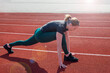 © Tania - Fitness and sports. Sporty girl stretching her legs at the stadium....